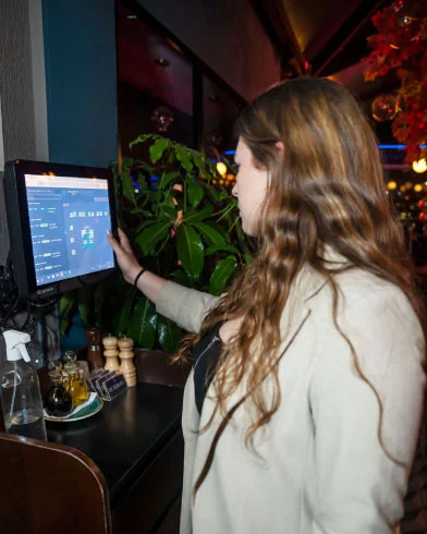 Mujer utilizando el software de punto de venta Infocaja Colombia en un restaurante